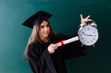 Female graduate student in front of green board 
