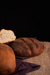 freshly baked bread on dark wooden kitchen table. Selective focus
