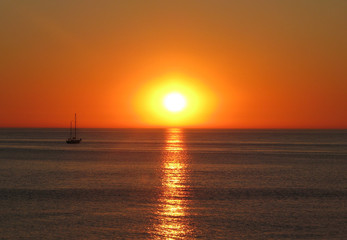 Naklejka na ściany i meble Ship on the background of the sunset on the sea.