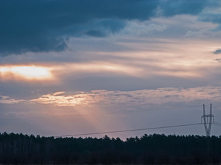 Promienie słońca przebijające się przez grubą warstwę chmur.