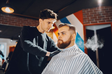 Man with a beard. Hairdresser with a client.