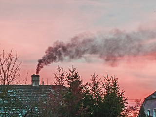 Dymiący komin na dachu domu. - obrazy, fototapety, plakaty