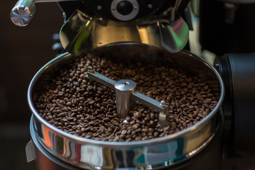 Freshly roasted aromatic coffee beans in a modern coffee roasting machine. Fresh Coffee Beans - Freshly roasted spinning cooler professional machine. Mixing roasted coffee.