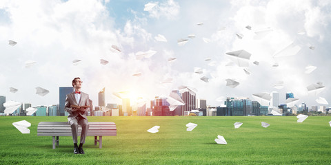 Young businessman or student studying the science and paper planes flying around