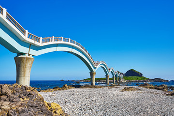 Beautiful scenic of Sanxiantai arch bridge with blue ocean with Three saint island in behind at Chenggong district in Taitung city, Taiwan.