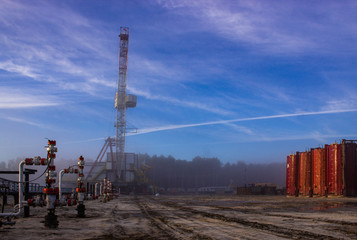 fountain fittings oil wells in the fog on the background of the rig in the morning