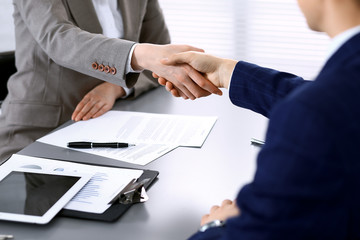 Business people shaking hands, finishing up a meeting. Papers signing, agreement and lawyer consulting concept