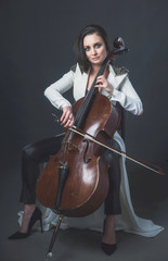 Beautiful woman in a white coat plays the cello