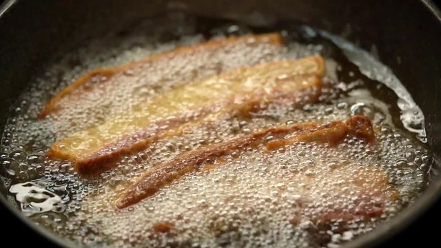  FHD Video CU SLO MO Slow motion selective focus stabilize close up macro shot fresh homemade deep fried crispy crunchy pork meat belly in boiling palm oil in frying pan.