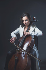 Beautiful woman in a white coat plays the cello