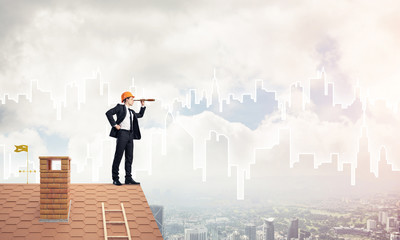 Engineer man standing on roof and looking in spyglass. Mixed med