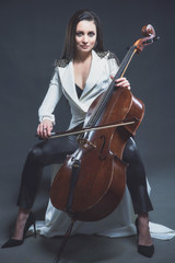 Beautiful woman in a white coat plays the cello