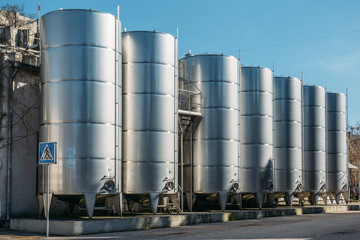 Obraz premium Modern aluminum or steel storage tanks or barrels for wine in winery factory production
