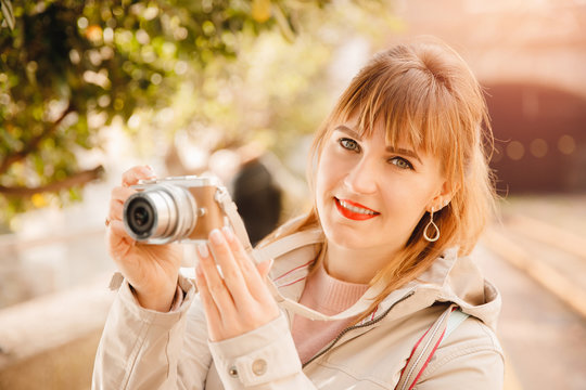 Traveler and photographer. Young woman smiles and makes lifestyle photo travel