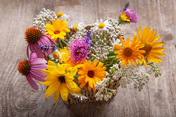 bouquet of field wild flowers in a vase on old boards