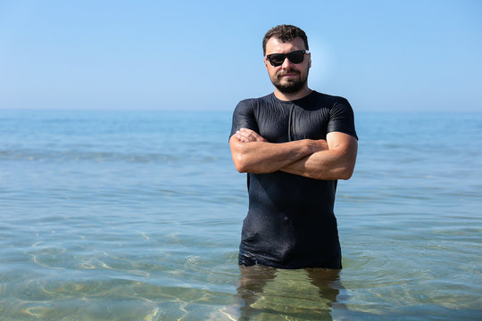A man in a wet t-shirt in the sea