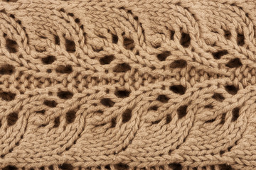 Close up on a beige knitted sweater as the background. Fashion design. Macro.