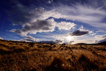 Countryside view against blue sky and sun