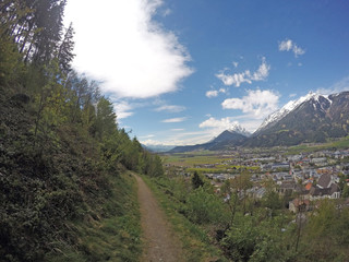Silent view over the Inn Valley and passing on the path through the forest in spring