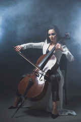 Beautiful woman in a white coat plays the cello © Антон Фрунзе
