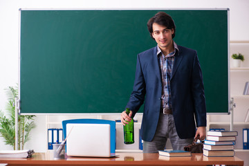 Male teacher drinking in the classroom 