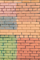 Fototapeta premium Brick wall from a new brick. The wall is painted with multi-colored paint of pastel tones