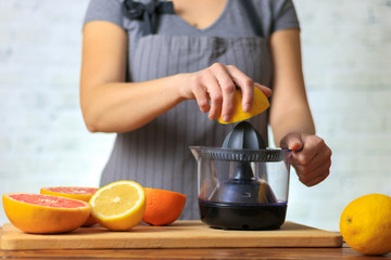 Woman squeezing lemon juice in kitchen