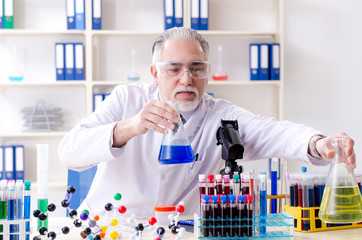 Old male chemist working in the lab 