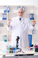 Old male chemist working in the lab 