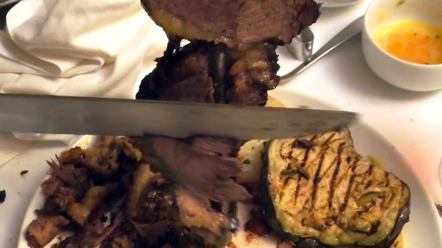 Close up of a picanha beef cutting. Set table blurred in Brazilian steak house.