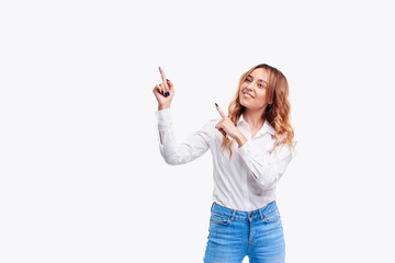 Happy surprised  young woman smiling broadly at camera, pointing fingers up, showing something...