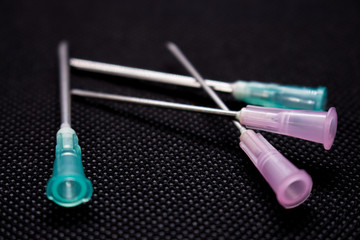 Cannula isolated on black background. Medical needle. Macro shot 