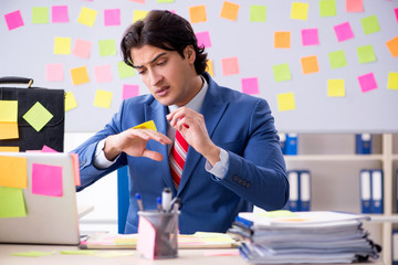 Young male handsome employee in conflicting priorities concept 
