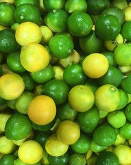 heap of raw yellow and green limes fruits pattern