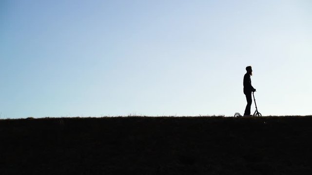 Shadow image of man riding kick scooter at public park, Zagreb, Croatia.