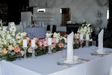newlyweds table in restaurant decoration fresh flowers and candles. Wedding fresh flowers decoration