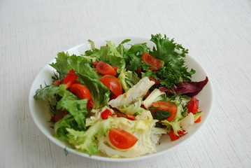 Vegetable salad for a healthy lunch consists of Petsay, Frize, Radicchio leaves. The salad has cherry tomatoes, red pepper, dill, olive oil.