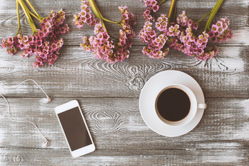 Naklejka na ściany i meble Social media flat lay with coffee, flowers and smartphone on gray wooden table.