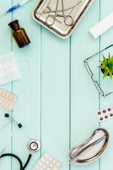 work desk of doctor in hospital with medical set frame on mint green background top view mockup