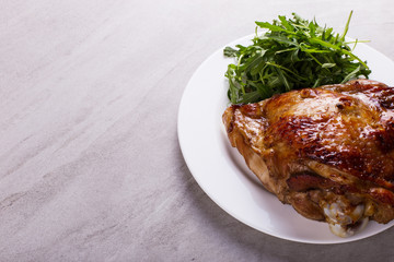 Thigh turkey baked in the oven with spices on a white plate on the tabletop. Healthy food. Thanksgiving dinner.