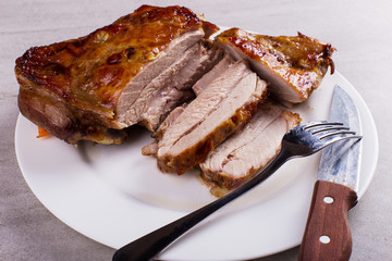 Thigh turkey baked in the oven with spices on a white plate on the tabletop. Healthy food. Thanksgiving dinner.