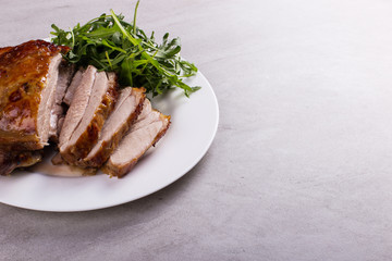 Thigh turkey baked in the oven with spices on a white plate on the tabletop. Healthy food. Thanksgiving dinner.