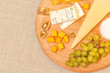 Assorted cheeses on round wooden board