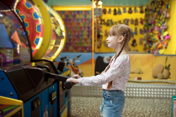 Little girl plays game machine, children center