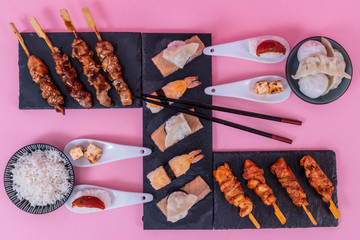 Asian food on black stone slate with chopsticks
