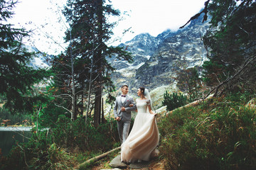Wedding couple walking near the lake in Tatra mountains in Poland. Morskie Oko. Beautiful summer day