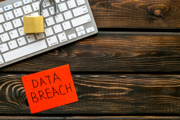 data breach concept with locker on keyboard on wooden background top view mock up