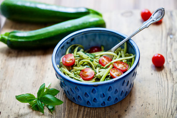 Zucchini spaghetti with rough basil and walnut pesto and cherry tomatoes