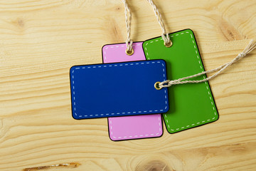 Multicolored blank label price tag on a background of light wood. Country style.