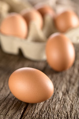 Raw brown egg with egg box in the back (Very Shallow Depth of Field, Focus on the front of the first egg)